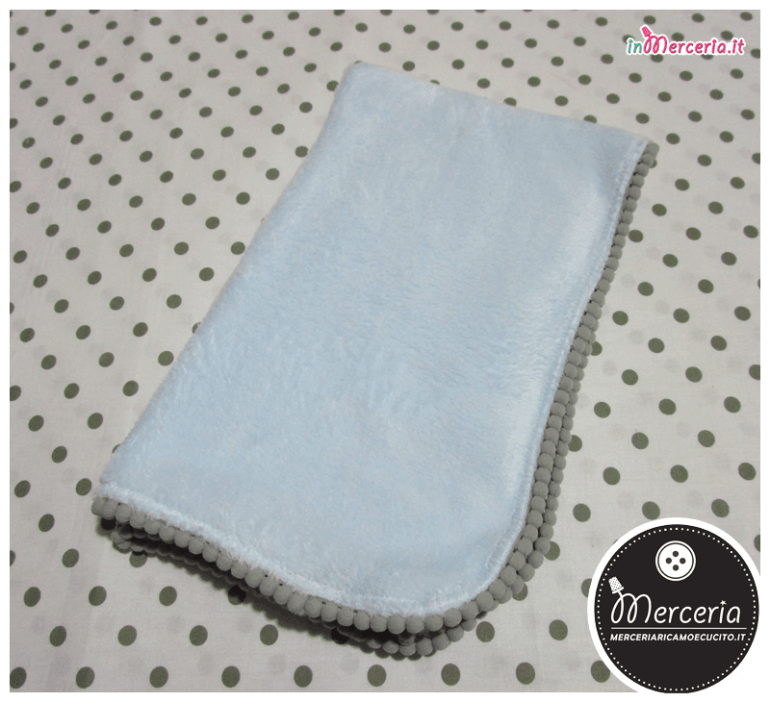 Copertina in ciniglia celeste con ponpon
